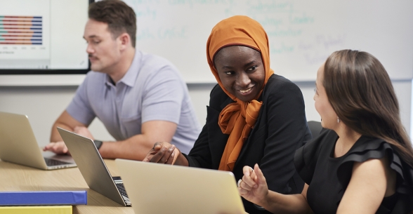 Image of diverse Thunderbird students talking with each other at a meeting