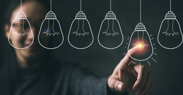 Woman touches a representation of a light bulb, indicating intelligence.