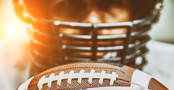 Image of a football player holding a football in an American flag.