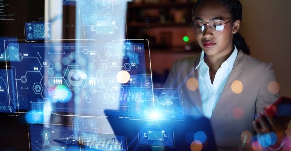 Image of a business woman in glasses and a suit working on a high tech see through holographic screen.