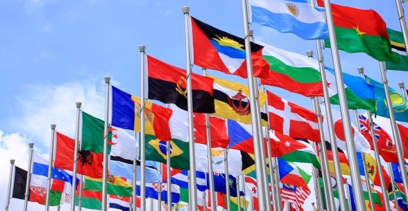 A variety of flags fly, representing globalization.