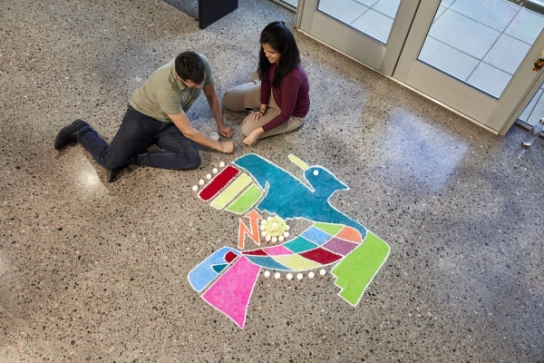 Thunderbird students creating a Thunderbird 75th Anniversary logo Rangoli for a Diwali celebration