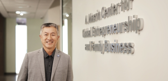 Image of Masrin standing in front of the Masrin Center sign at Thunderbird Global Headquarters