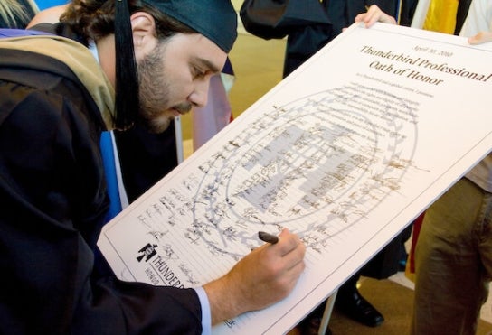 Thunderbird graduate signing the Oath of Honor at commencement